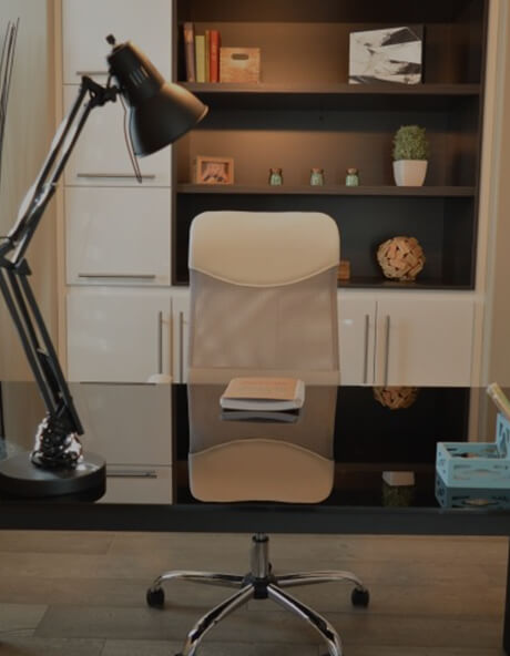 A desk with a chair and lamp on it